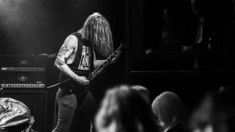 Guitarrista de metal tocando en vivo frente a un amplificador