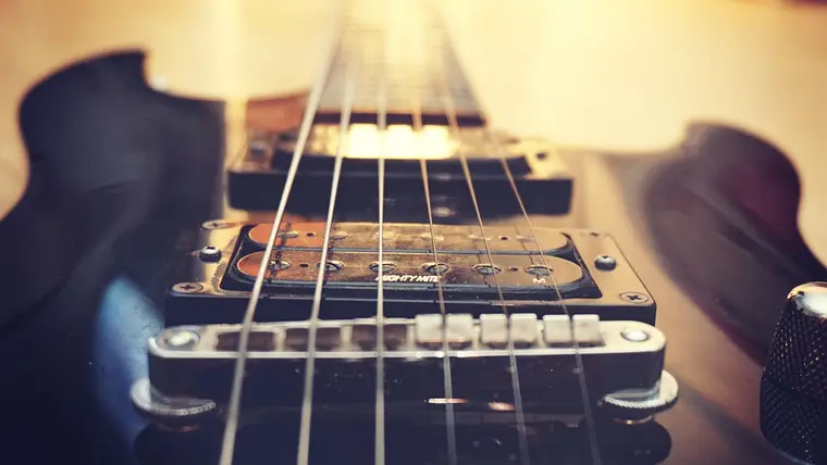 Cuerdas y pastillas de una guitarra eléctrica en primer plano