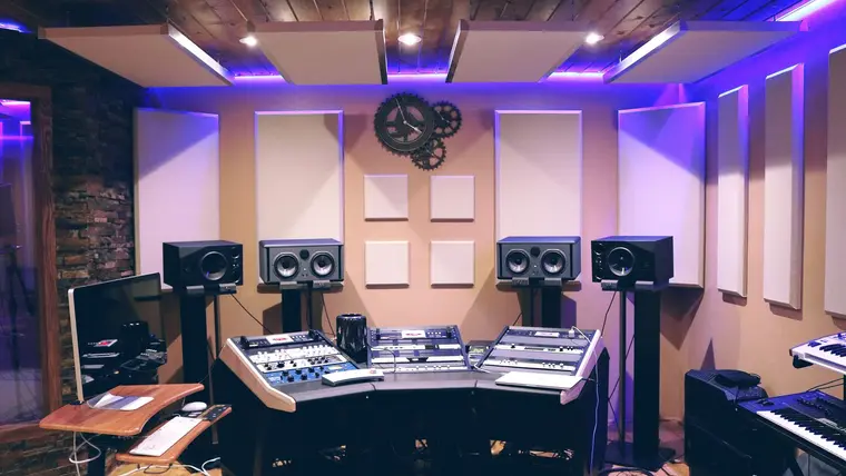 Sala de estudio con monitores y paneles acústicos en las paredes