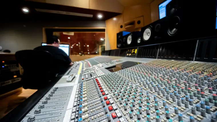 Consola de mezcla y monitores en la sala de control de un estudio de grabación