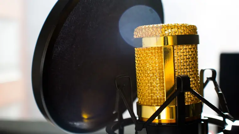 Micrófono de condensador dorado con filtro antipop en un estudio de grabación