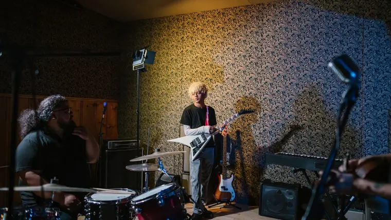 Banda de rock ensayando en un cuarto de ensayo con batería y guitarras